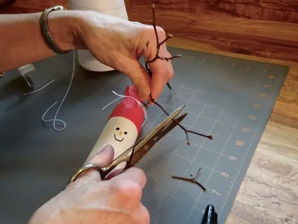 adding wood twig arms to snowman Christmas cracker