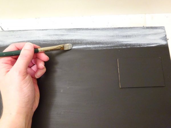painting a black sign with white paint