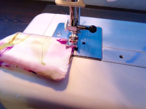 machine sewing together the ends of a diy purse scarf