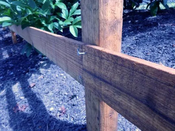 Fence rail tacked to a post with a nail