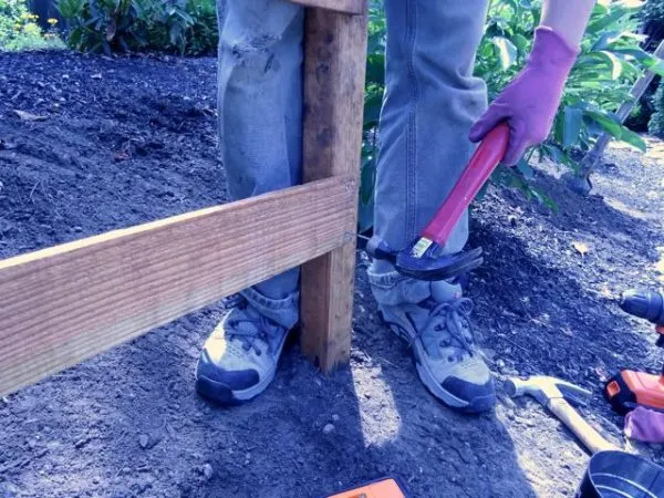 Hammering nails into a fence rail