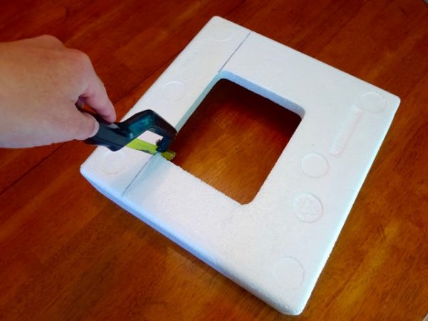 Cutting a block of styrofoam with a small hand saw