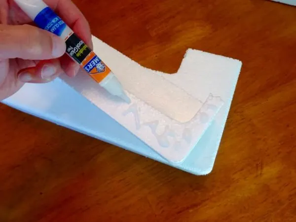 Applying white glue to foam blocks to secure them together and create a display rack