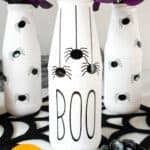 white glass bottles with spider decals on them
