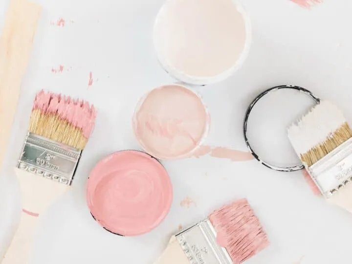 jars of pink paint samples with brushes on white background