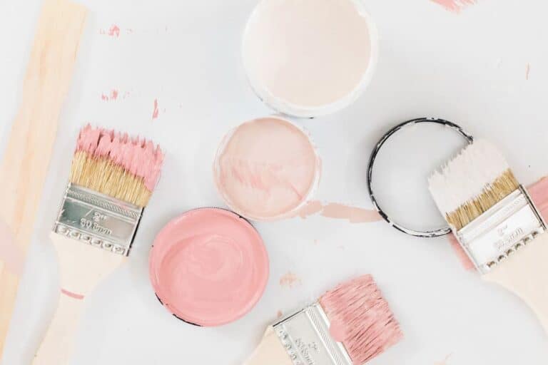 jars of pink paint samples with brushes on white background
