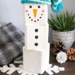 diy wood block Snowman craft with blue cap on table