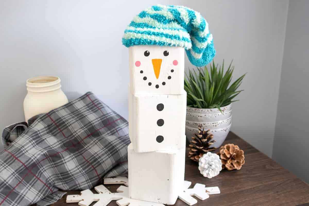 painted wood block Snowman with blue cap on table
