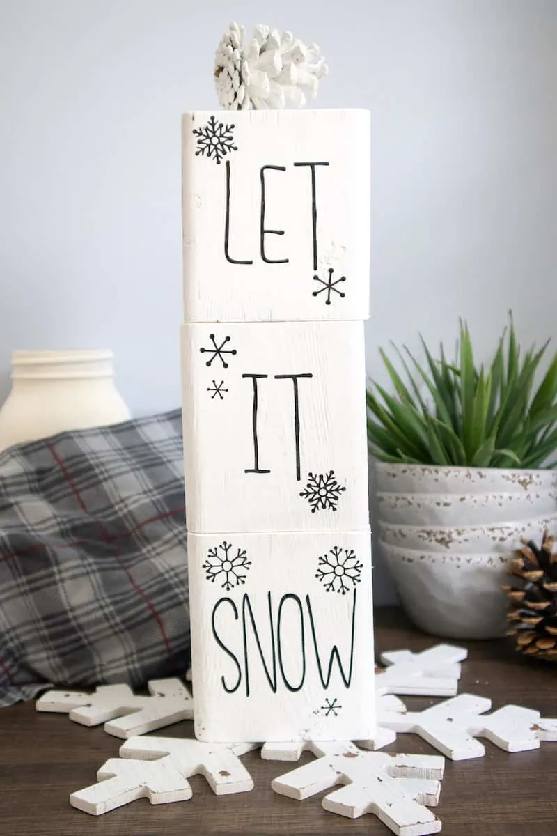 stacked painted wood block Snowman word stencils on table
