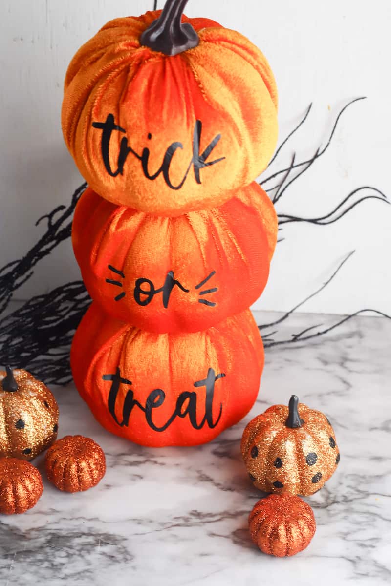 stacked dollar store pumpkins with cricut trick or treat sign