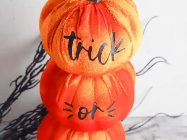 stacked dollar store pumpkins with cricut vinyl letters