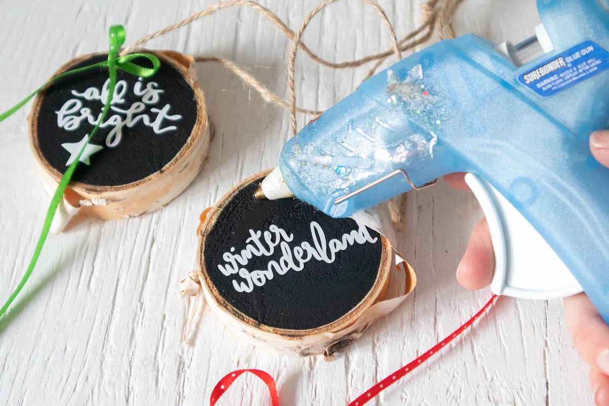 glue gun and lettered wood slice ornaments