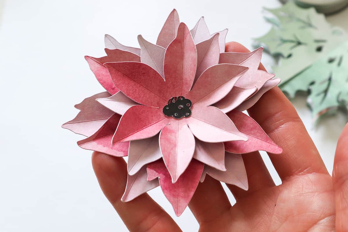 closeup of 3D paper poinsettia flower in hand