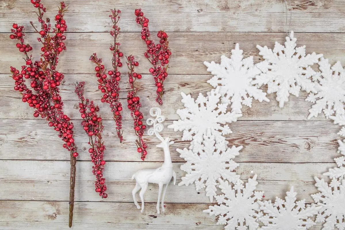 red berry picks next to snowflake wreath