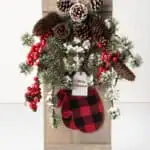 wooden Christmas sign with pine cones and mittens