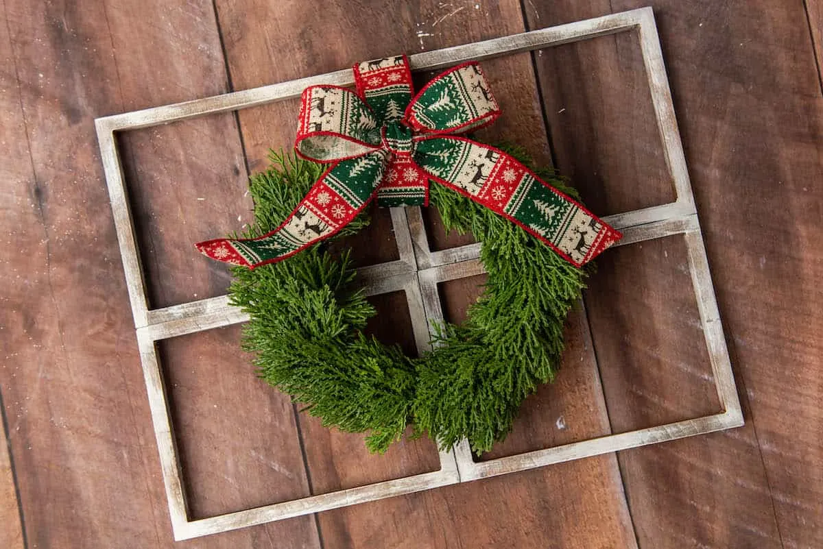 Christmas wreath with bow on a faux window
