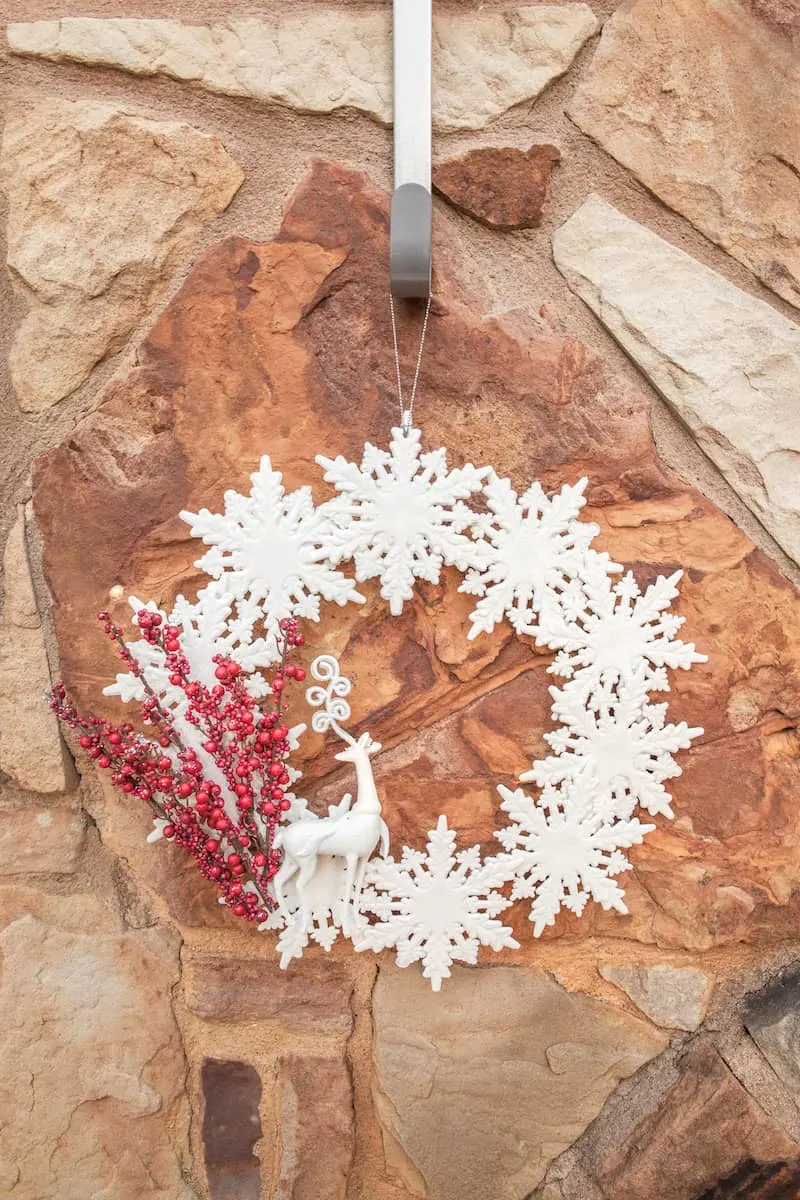 snowflake and deer wreath hanging on a rock wall