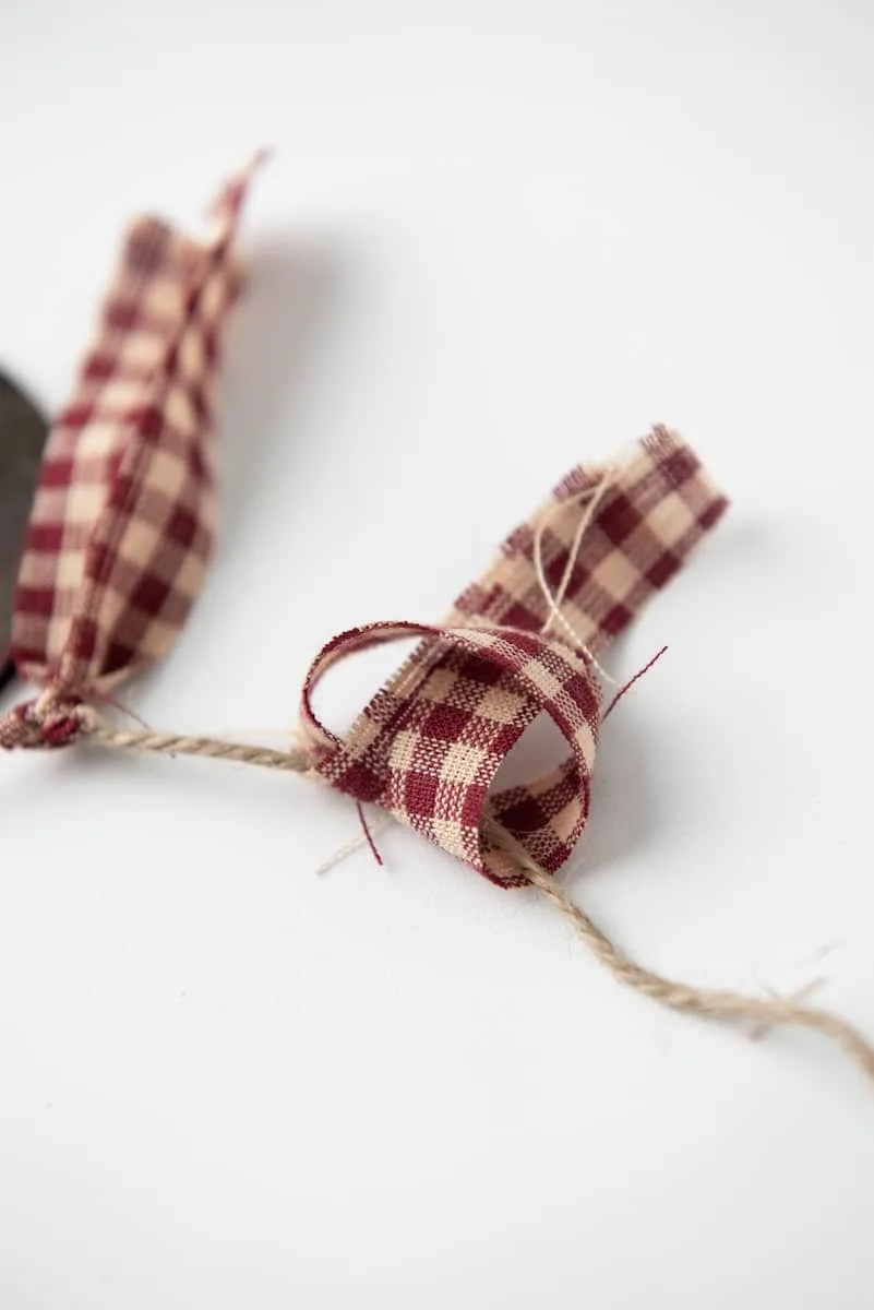 Tying Checkered Ribbon to Twine Banner