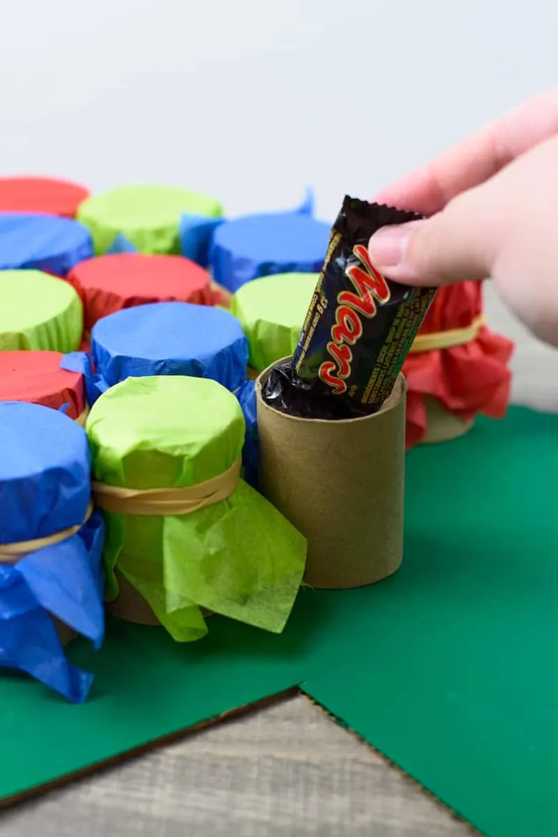 adding candy into a paper tube roll