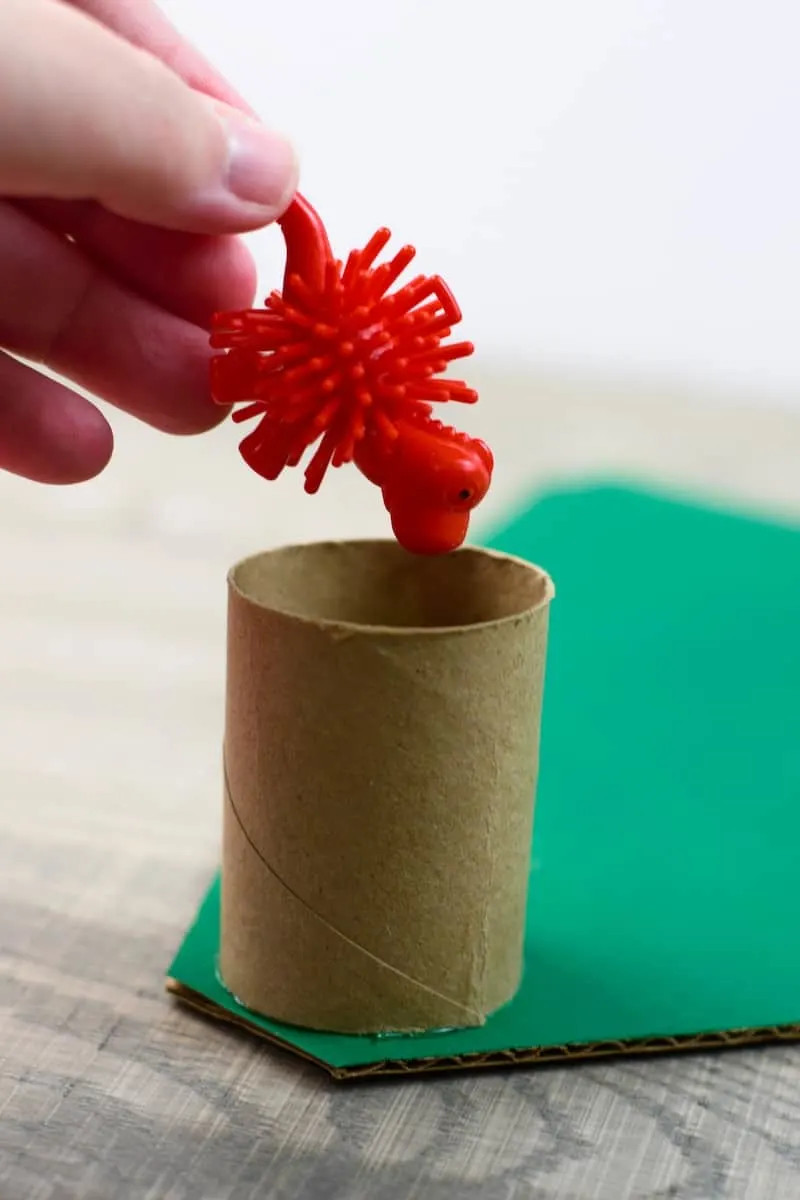 putting small toy into paper roll on advent calendar