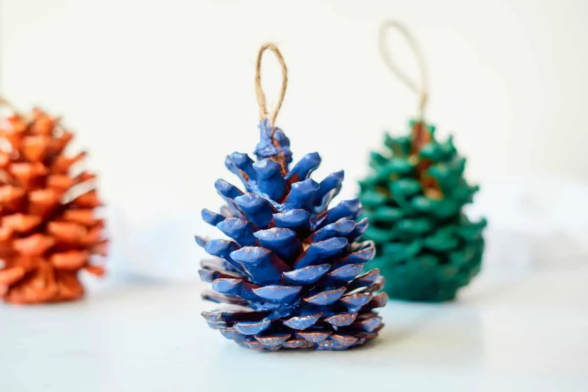 blue green and red wax covered pine cones