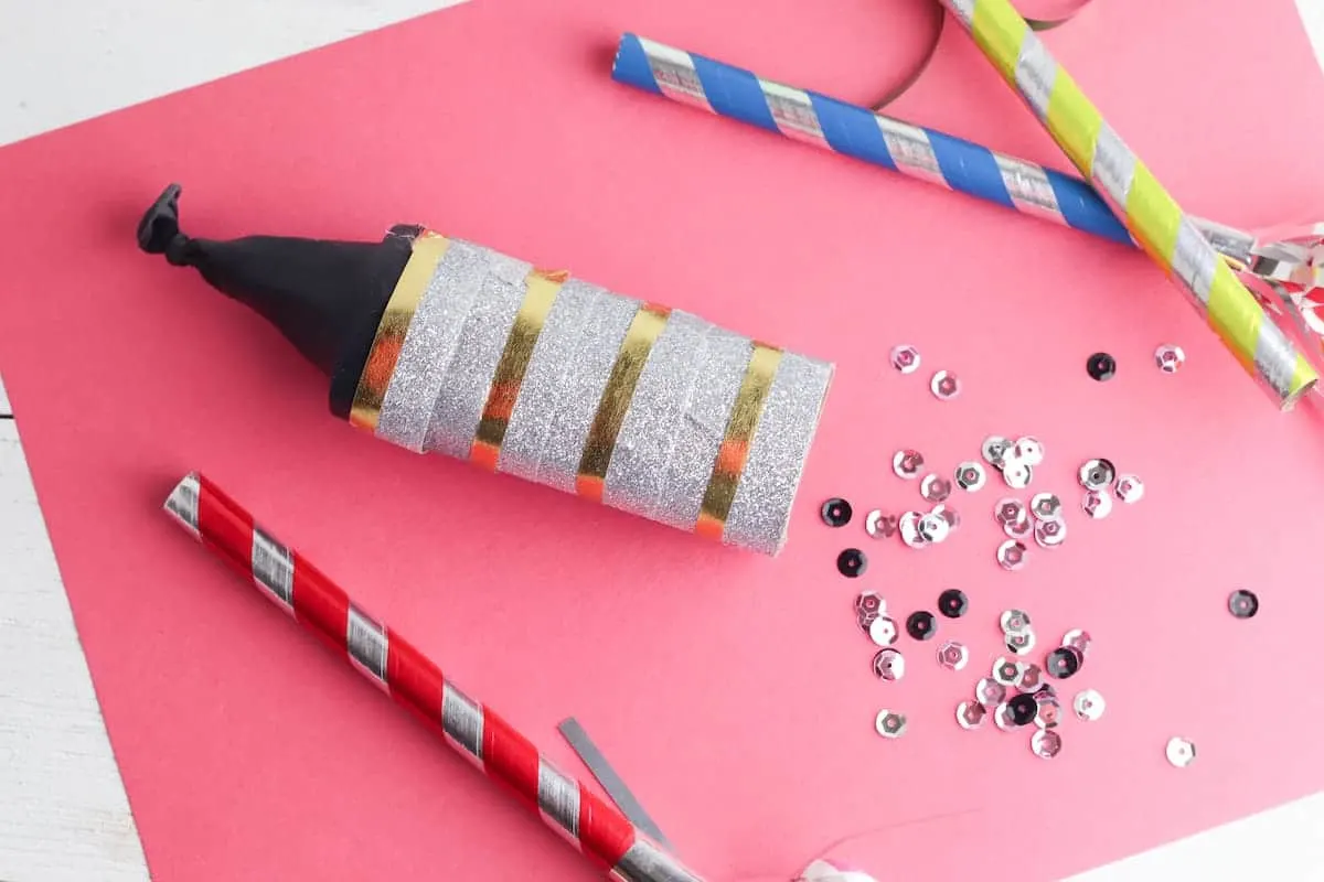 doy confetti cannon on pink background with sequins nearby