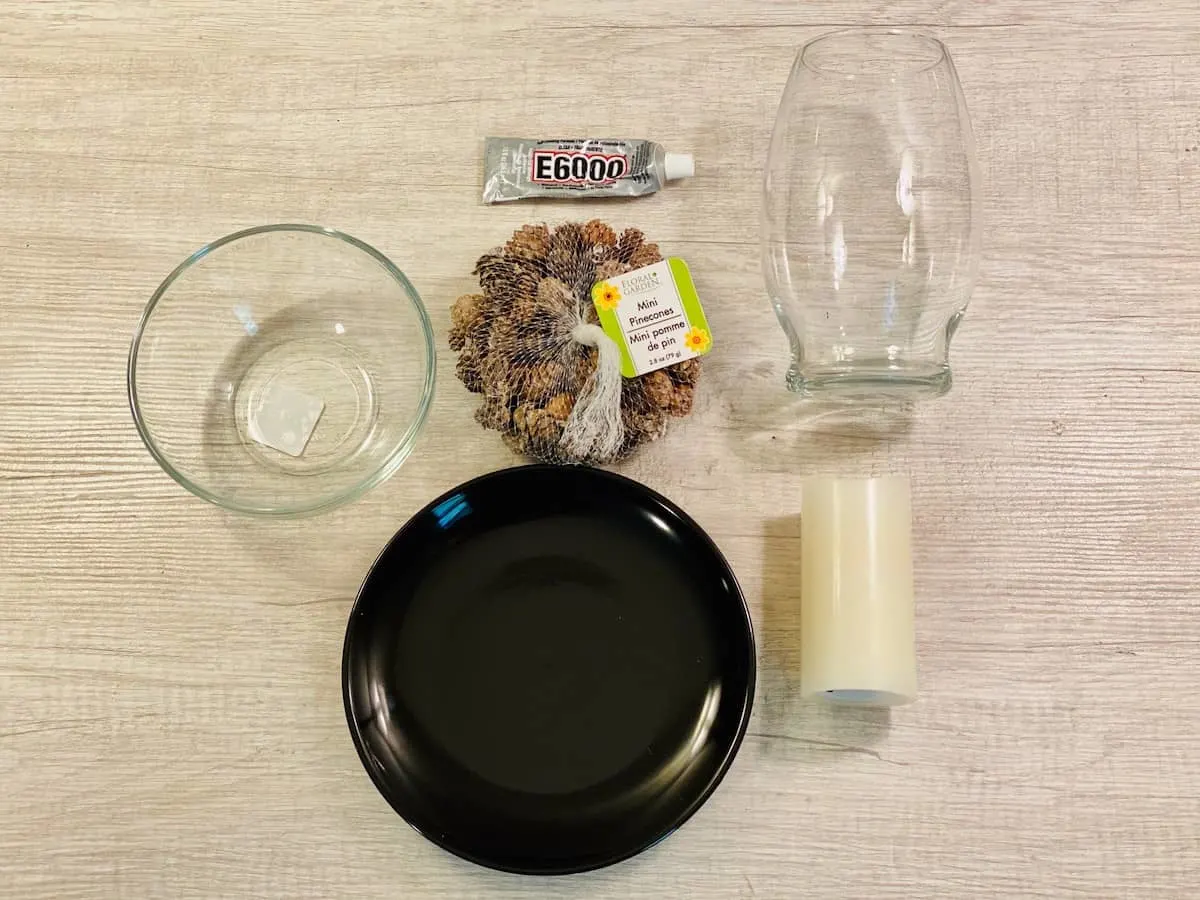 black plate and glass bowls with pinecones supplies