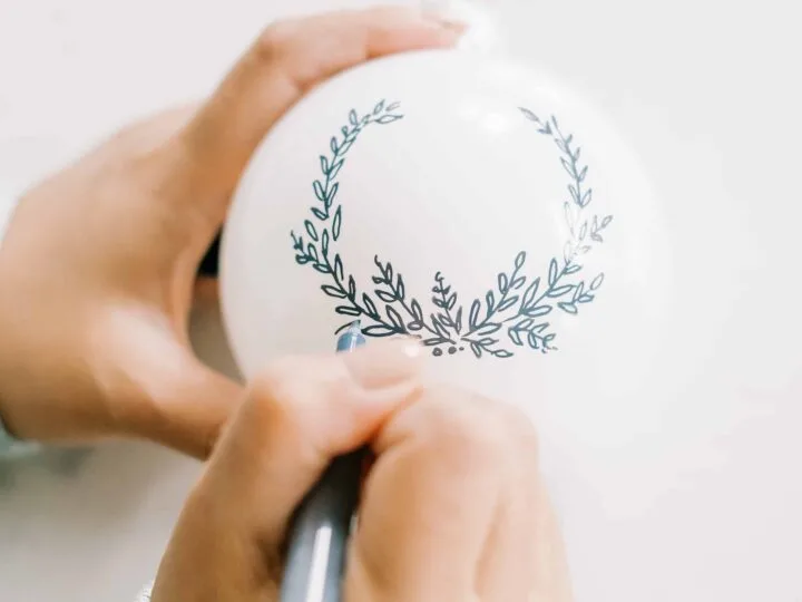 woman painting a Christmas ornament