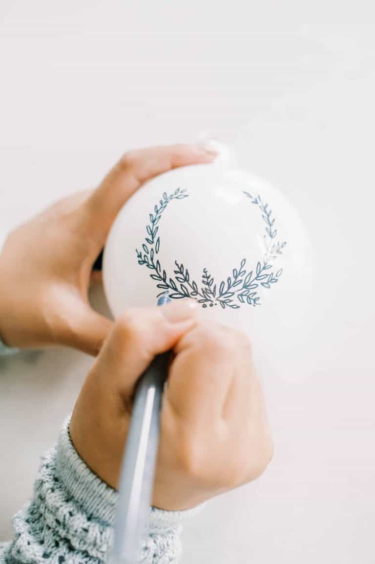woman painting a Christmas ornament