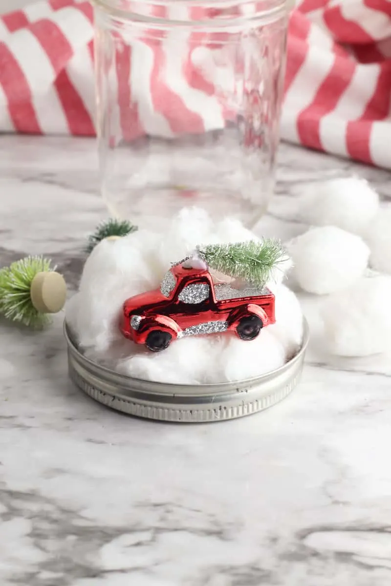 red truck ornament and cotton balls on mason jar lid