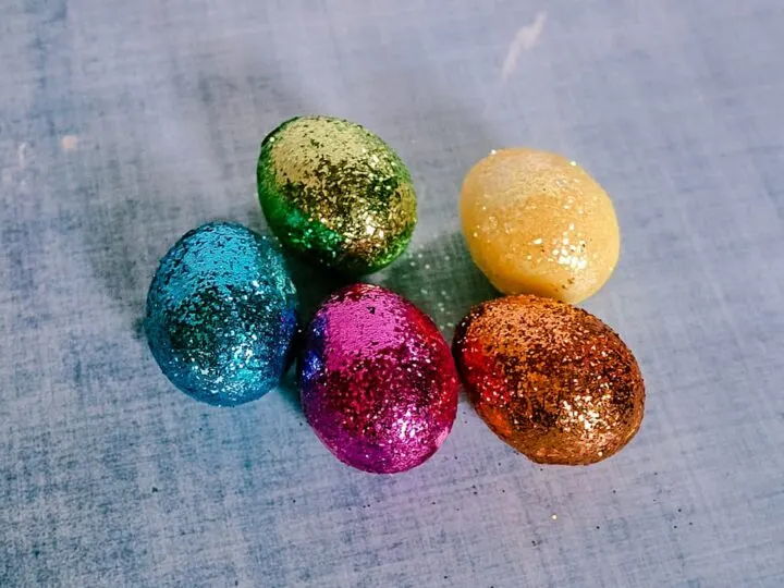 DIY Glitter Easter eggs on blue background