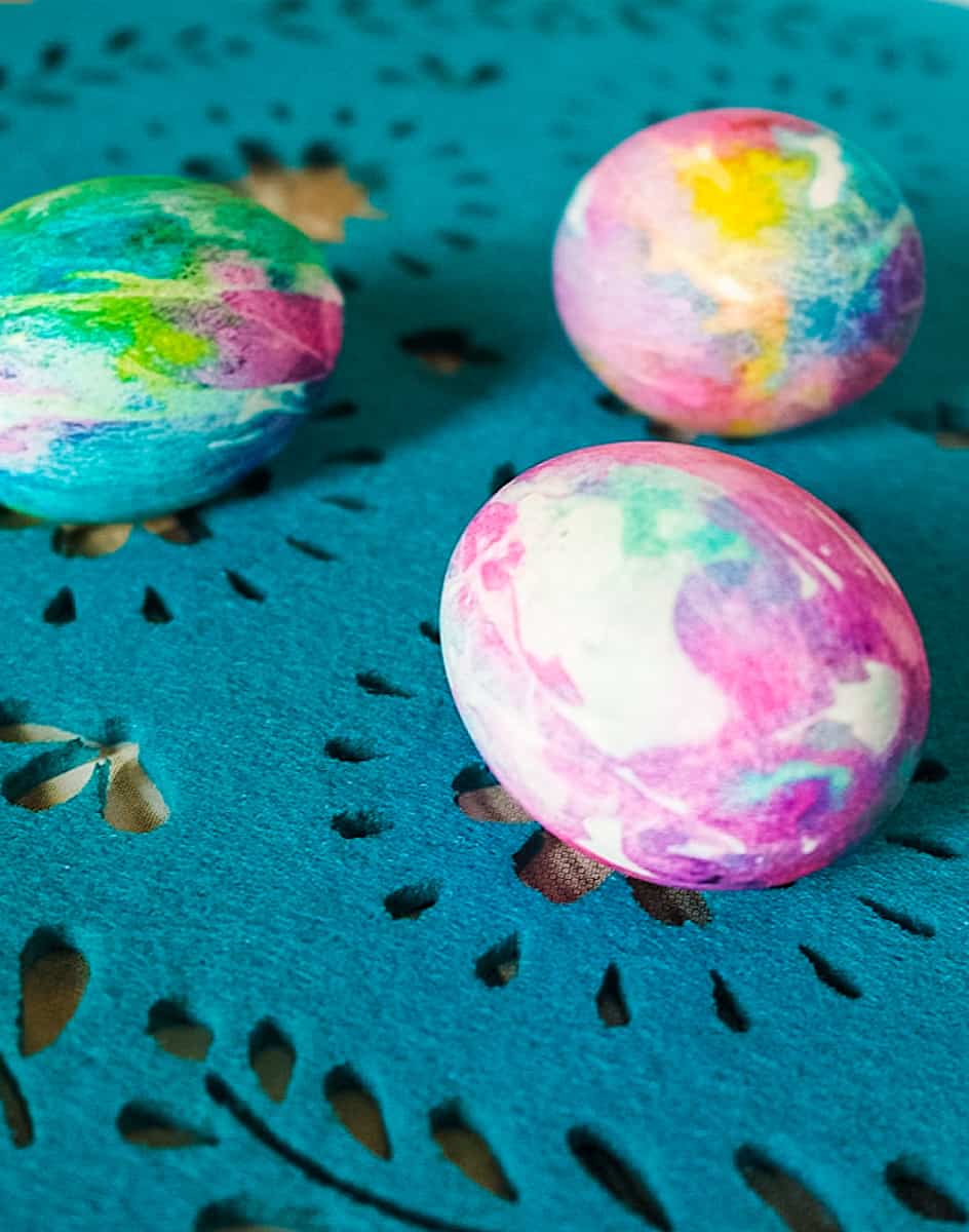 colorful tie dyed Easter eggs on blue placemat