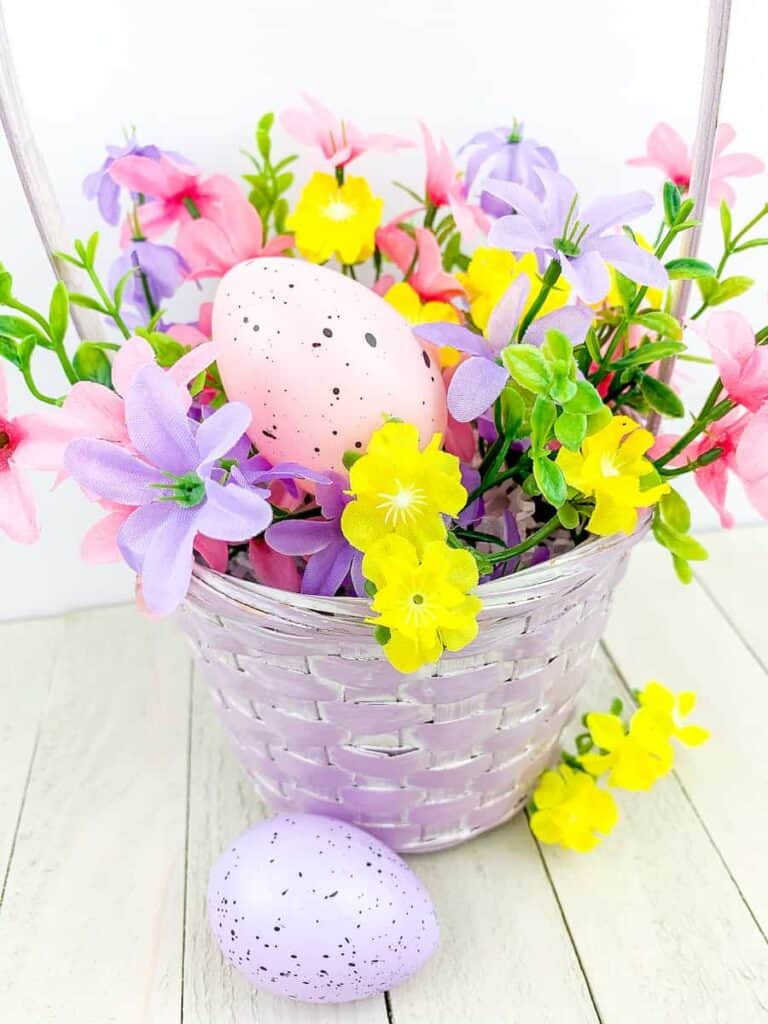 Easter eggs and flowers in a purple basket