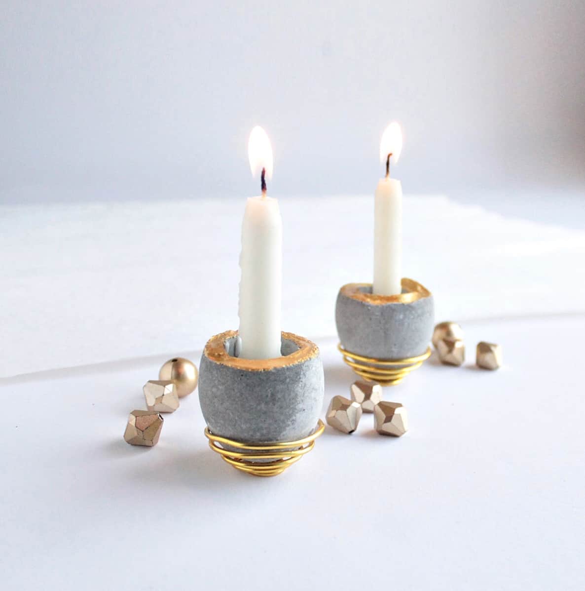 small cement candleholders with burning taper candles