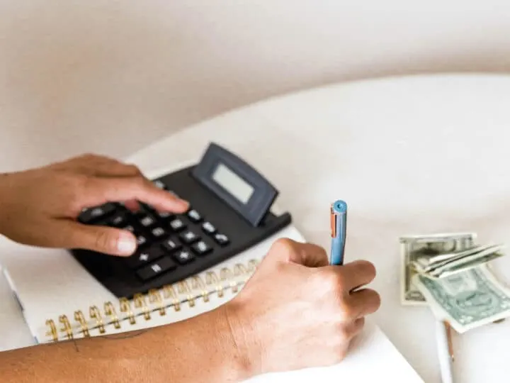 woman using a calculator to budget