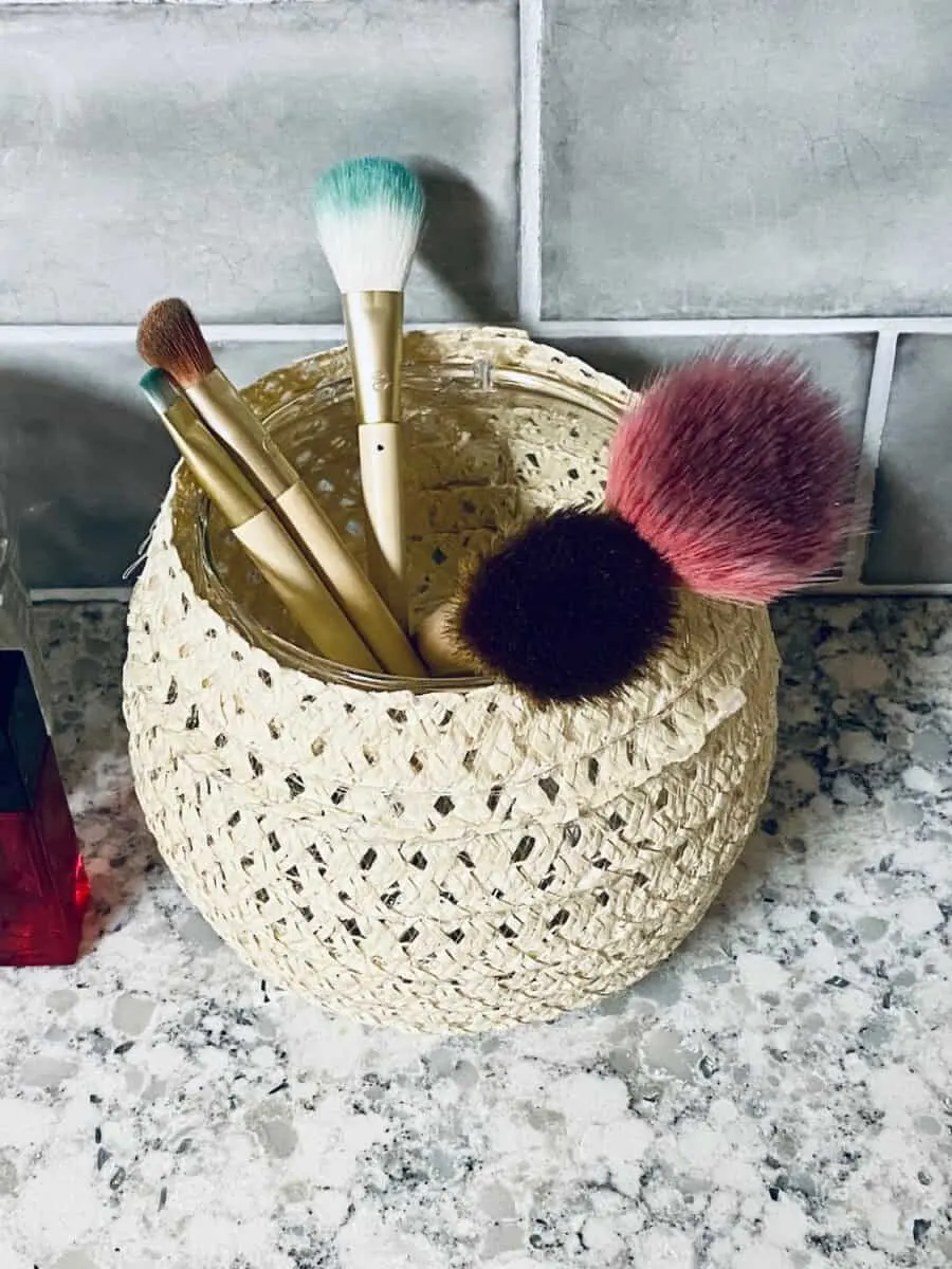 makeup brushes in a wicker vase
