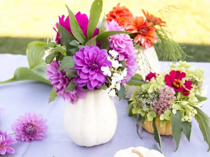 diy pumpkin vases with colorful flowers inside