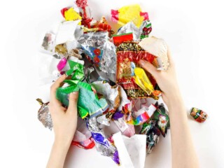 hands holding a pile of candy wrappers