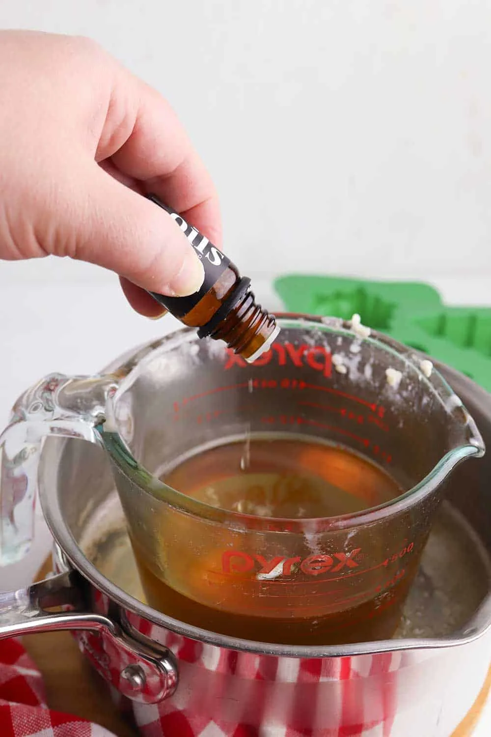 adding essential oils into melted beeswax