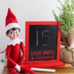 countdown to Christmas chalkboard next to stuffed elf on a shelf