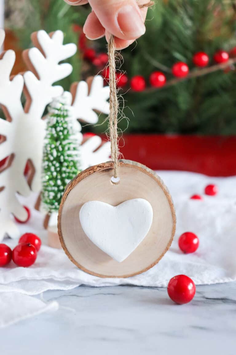 wood round ornament with white clay heart glued in center