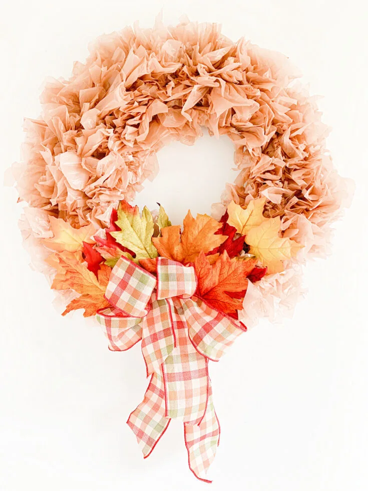 DIY fall wreath made from brown plastic bags hanging on a front door