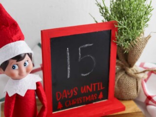 elf on the shelf sitting next to DIY Christmas countdown chalkboard