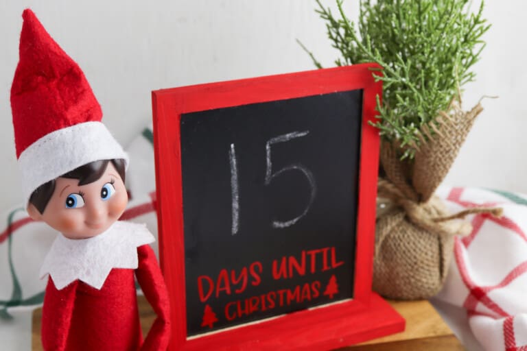 elf on the shelf sitting next to DIY Christmas countdown chalkboard