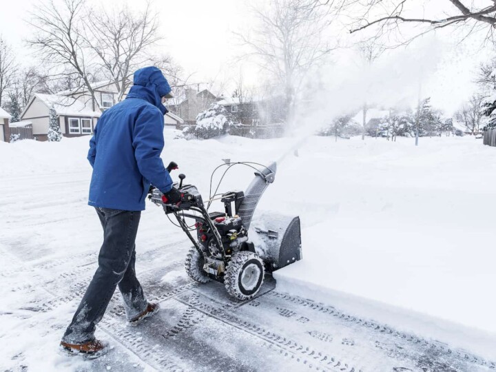 person using a snowblower in snow