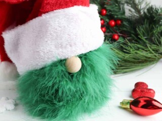 handmade Grinch gnome against Christmas greenery