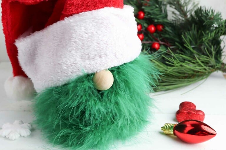 handmade Grinch gnome against Christmas greenery