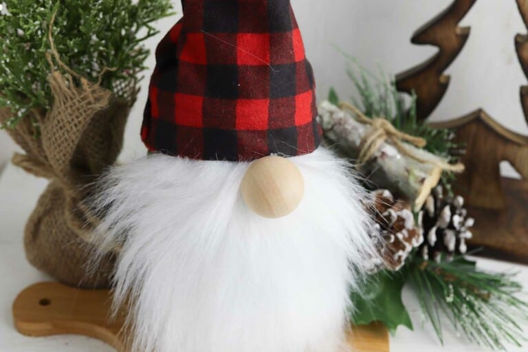 gnome made with a mason jar against a Christmas greenery backdrop