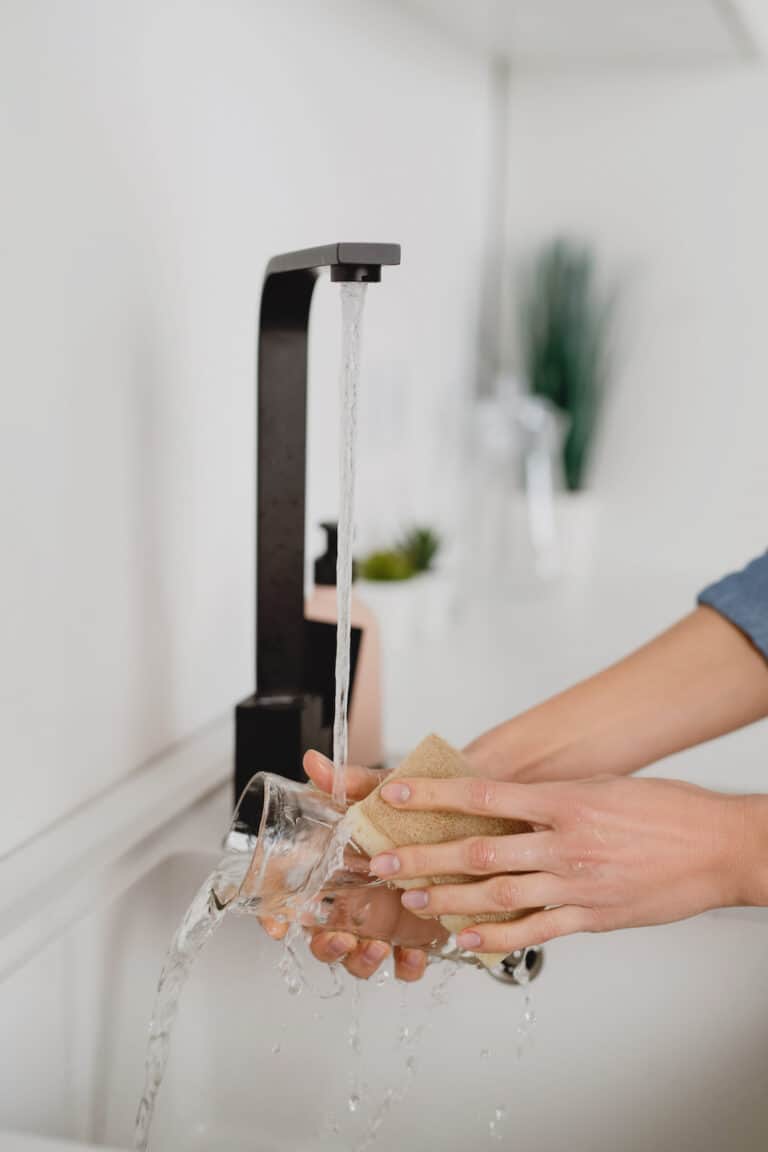 woman washing dishes in sink