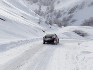 car driving on a snowy road in the mountains
